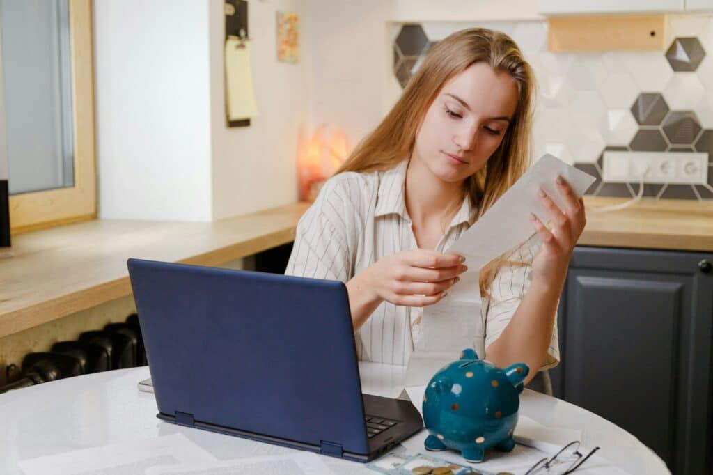 Woman checks sales receipt after shopping. Returning goods, calculating costs, planning own budget